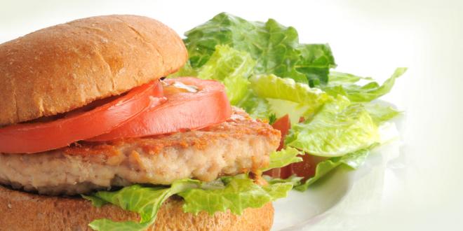 Chicken burger with sliced tomato and lettuce on toasted bun