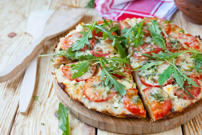 Small homemade pizza on a wooden plate
